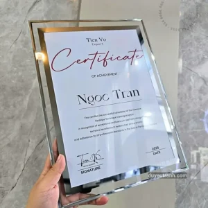 Khung bằng khen kính pha lê cầm trên tay