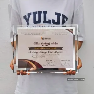 Khách nhận khung kính pha lê kèm giấy chứng nhận tại xưởng Duyên Tranh