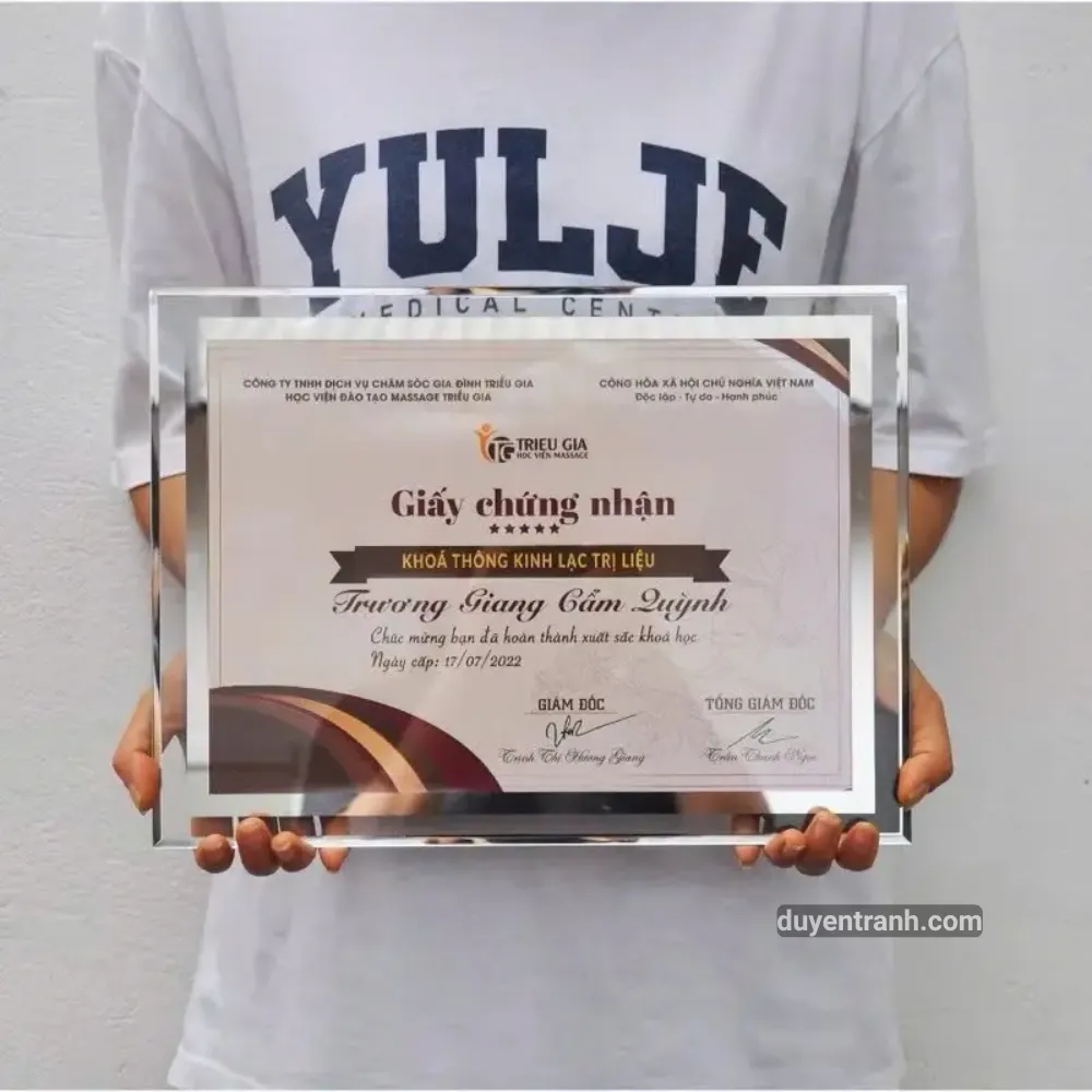 Khách nhận khung kính pha lê kèm giấy chứng nhận tại xưởng Duyên Tranh